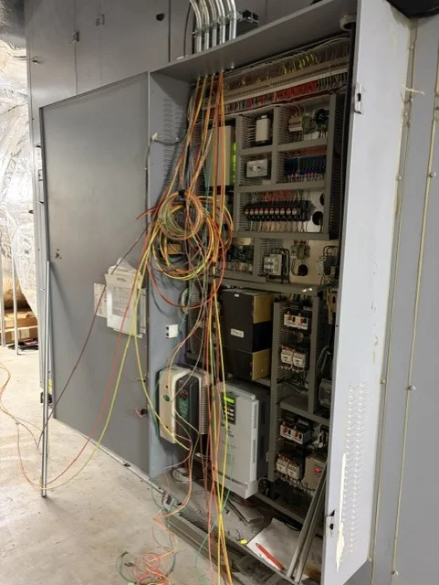 Heat recovery unit control panel opened during rewiring, with new drives and controls wiring inside