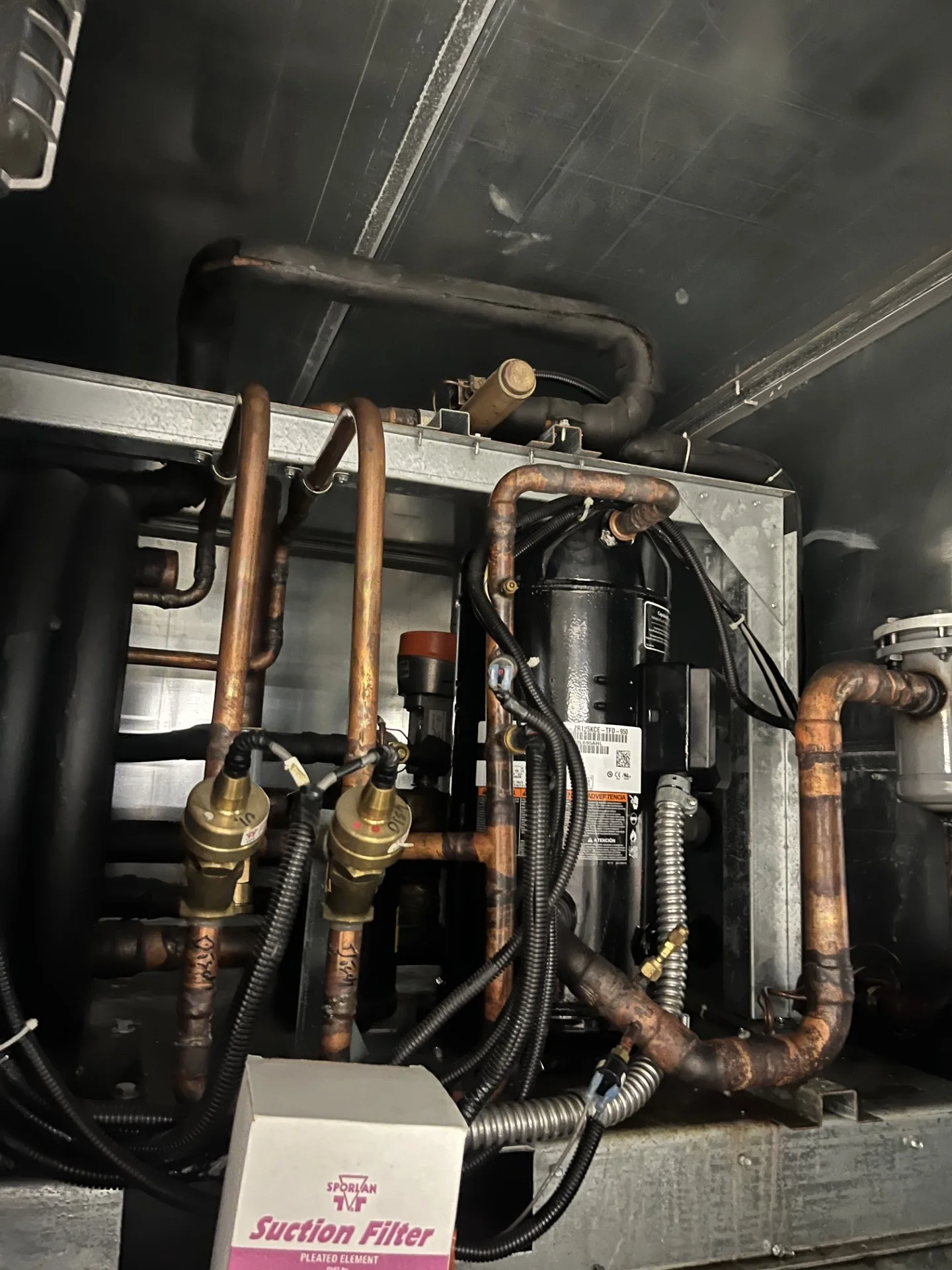 Compressor and copper refrigerant piping inside a heat recovery unit during the Cooper High School controls work