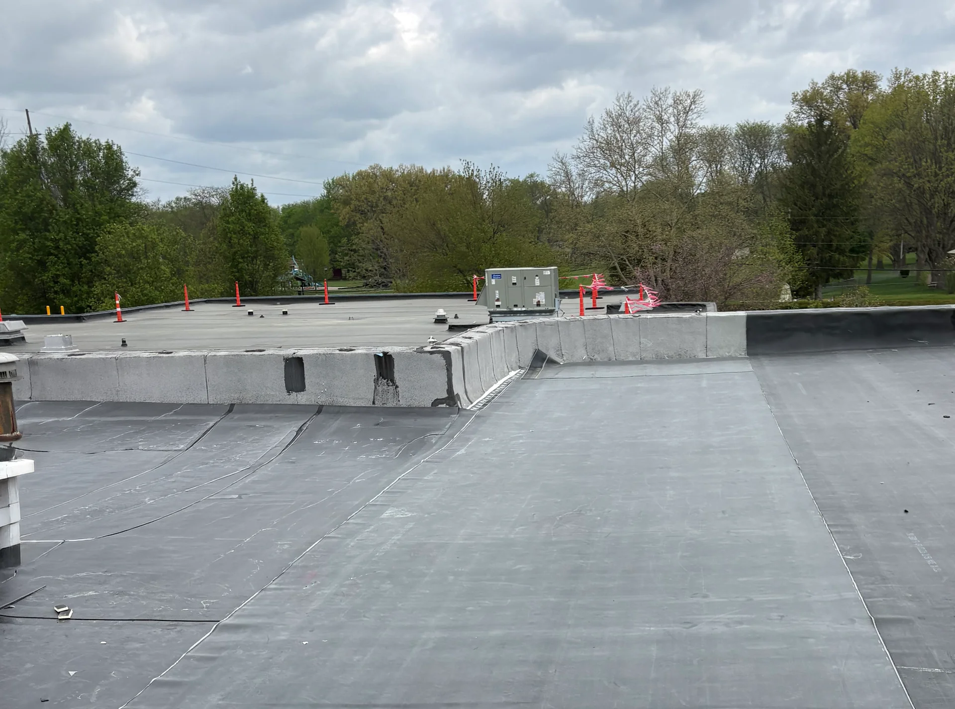 Completed black EPDM roof at Primary Village North, with the membrane carried up the parapet walls